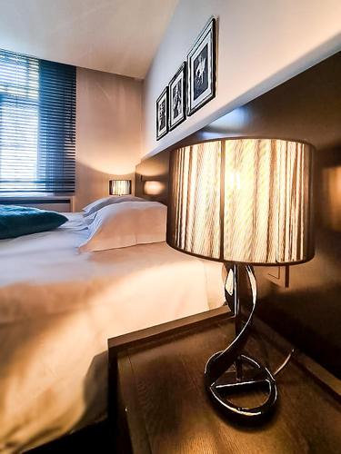 a bedroom with a bed and a lamp on a table at Villa Tilia in Retie