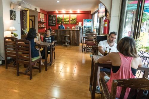 um grupo de pessoas sentadas em mesas em um restaurante em Kamala's Boutique Guesthouse em Chiang Mai