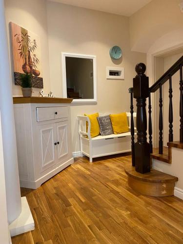 a living room with a staircase with yellow pillows at ApartamentS in Râşnov