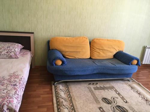 クルスクにあるApartament on Prospect Pobedy 44のベッドの横の部屋に青いソファが備わります。
