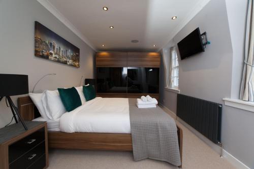 una camera con un grande letto e una televisione di Queensferry Street Lane - Fantastic 2 BR City Centre Mews House with free secure parking! a Edimburgo