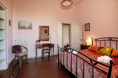 1 dormitorio con cama, mesa y escritorio en Agriturismo San Leonardello, en San Leonardello