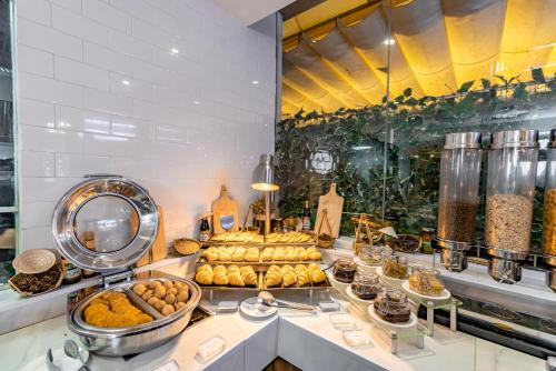 um buffet com pão e outros alimentos num balcão em Bay Hotel Ho Chi Minh em Cidade de Ho Chi Minh