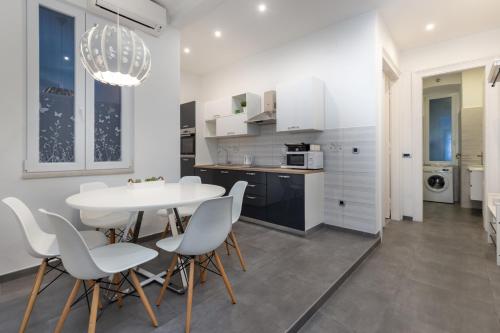 cocina y comedor con mesa blanca y sillas en Apartment LUX HOME, en Rijeka