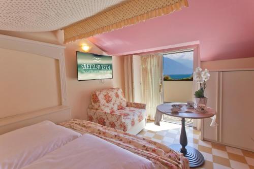 a bedroom with a bed and a chair and a table at Bellavista Lakefront in Riva del Garda