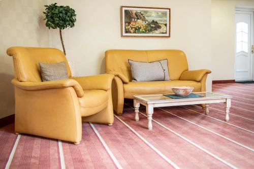 two chairs and a coffee table in a living room at Hotel Wardenburger Hof in Wardenburg