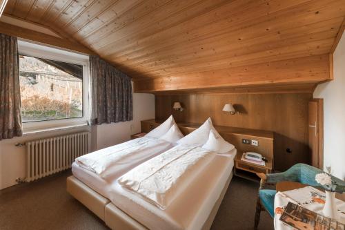 a bedroom with a large bed and a window at Pension zum Burggräfler in Schenna