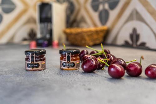 two jars of jam next to a bunch of cherries at Achinos By The Sea Milos in Agia Irini Milos