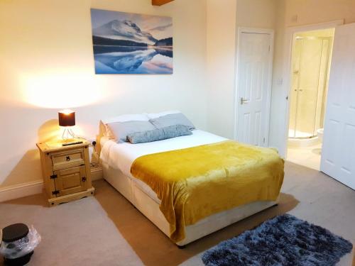 a bedroom with a bed and a table with a lamp at Highfields Town House in Huddersfield