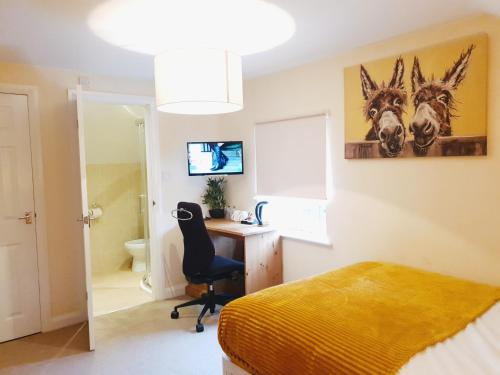 a bedroom with a desk and a bed and a chair at Highfields Town House in Huddersfield