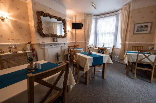 a dining room with two tables and a mirror at Appley Lodge in Shanklin