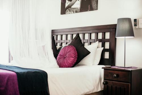 a bedroom with a bed with black and white pillows at Little Eden St Lucia in St Lucia