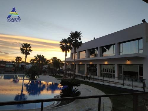 un edificio con una piscina y palmeras delante de él en Resort Camping Almafrá, en Benidorm