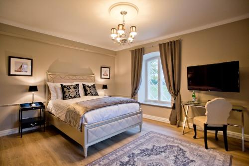 a bedroom with a bed and a tv and a window at Schloss Fall, Keila-Joa in Keila-Joa