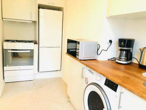 a kitchen with a washing machine and a refrigerator at aday - Reberbansgade Central Apartment in Aalborg
