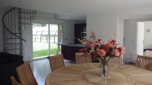 a vase of flowers on a table in a room at La Part des Anges in Rubercy