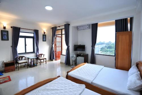 une chambre avec deux lits et un salon dans l'établissement Truong An Hotel, à Vung Tau