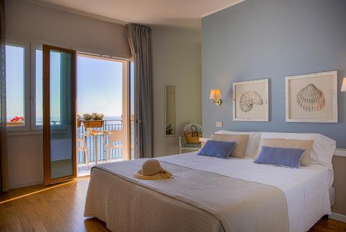um quarto com uma cama grande e uma varanda em Hotel Punta Nord Est em Castellammare del Golfo