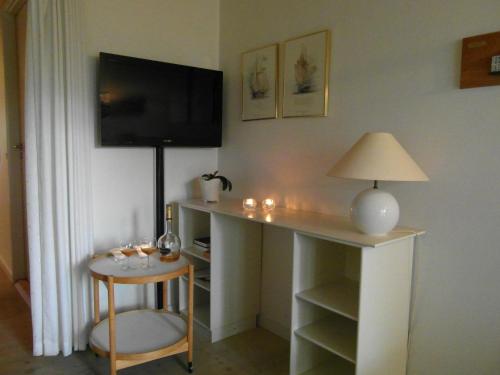 a room with a desk with a lamp and a table at Vigen ferielejligheder in Ebeltoft
