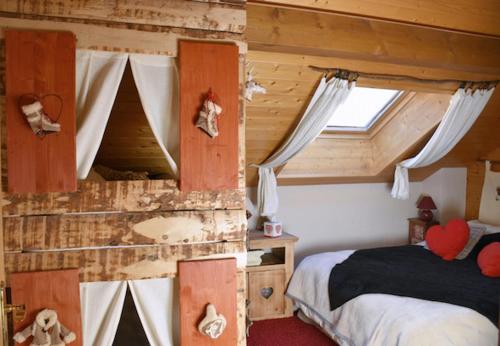 - une chambre avec un lit dans une cabane en rondins dans l'établissement L'Eglantine, à Champéry