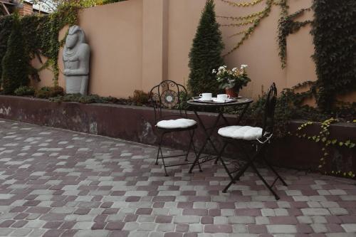 a table and chairs with a statue in a courtyard at Ekaterinoslav in Dnipro