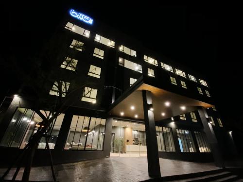 a lit up building at night with a sign on it at bliQ Hotel Chanthaburi in Chanthaburi