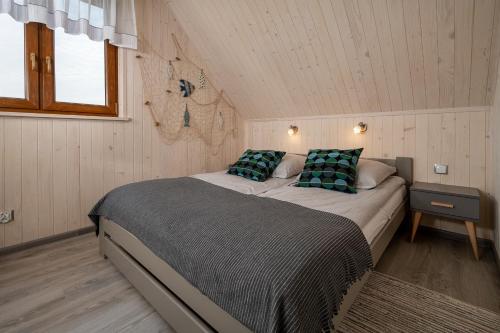 1 dormitorio con 1 cama grande en una habitación en Domki Magnati en Władysławowo