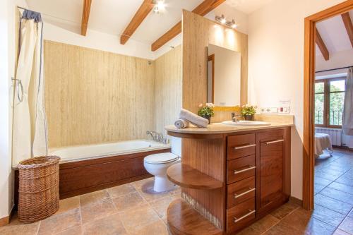 a bathroom with a tub and a toilet and a sink at Villa Muscarolas By home villas 360 in Pollença