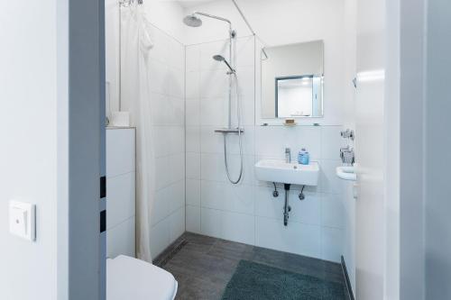uma casa de banho branca com um chuveiro e um lavatório. em Perm em Münster