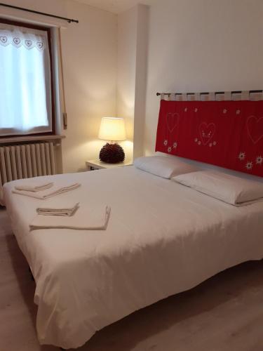a bedroom with a large bed with a red headboard at La Casetta Del Dahu in Limone Piemonte