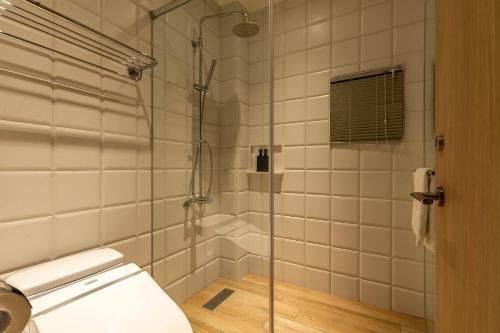 a bathroom with a glass shower with a toilet at Sleeping Inn in Hualien City