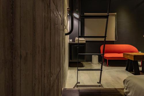 a room with a red chair and a ladder at Sleeping Inn in Hualien City
