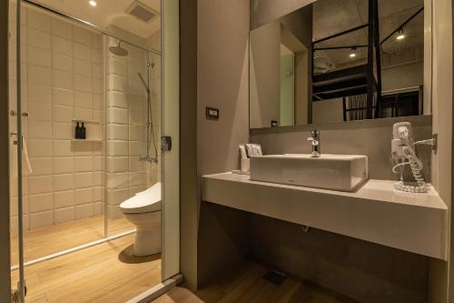 a bathroom with a sink and a toilet at Sleeping Inn in Hualien City