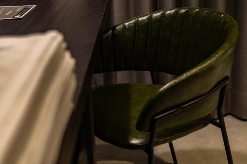 a green chair sitting next to a table at Sleeping Inn in Hualien City
