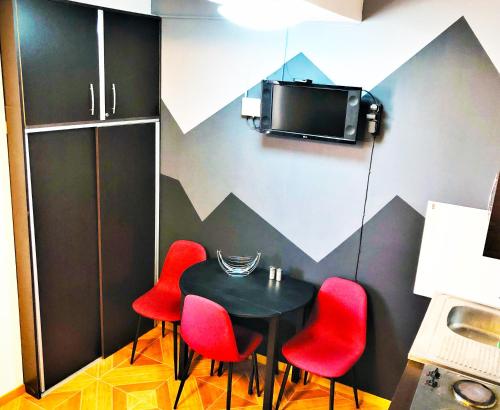 a table and four red chairs in a room at Marco Polo, Mountain View Apartment in Gudauri