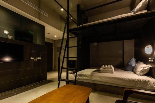 a bedroom with two bunk beds and a table at Sleeping Inn in Hualien City