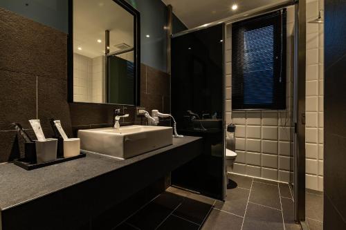 a bathroom with a sink and a toilet at Sleeping Inn in Hualien City