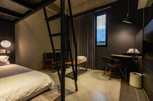 a bedroom with a bunk bed and a table and a desk at Sleeping Inn in Hualien City