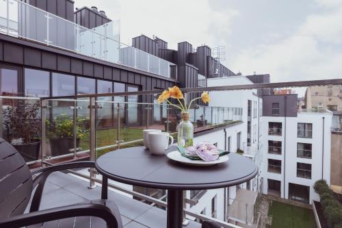 - une table avec un vase de fleurs sur le balcon dans l'établissement Exclusive Apartments Mostowa by Renters Prestige, à Poznań