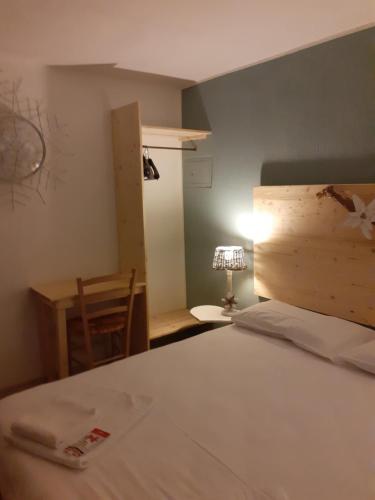 a bedroom with a bed and a table and a lamp at La Casetta Del Dahu in Limone Piemonte