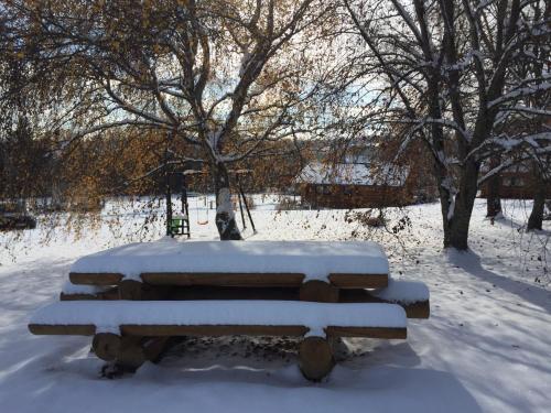 a bench covered in snow in a park at Rêves de Bois in Loubeyrat
