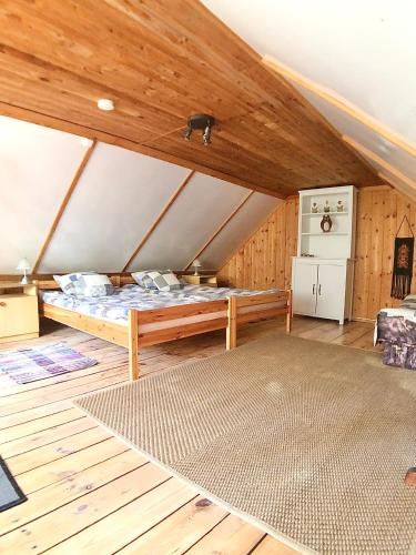 a large room with a bed in a attic at Pod lipą in Ruciane-Nida