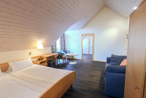une chambre d'hôtel avec un lit, un canapé et une table dans l'établissement Berggasthof Höchsten, à Illmensee
