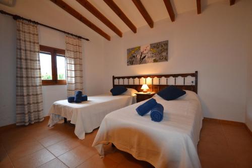 een slaapkamer met twee bedden met blauwe kussens erop bij Casa de Campo con Encanto in Pollença