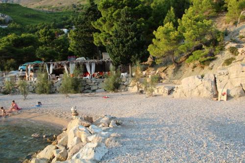 a group of people on a beach with a waterfall at Luxury Apartments Tafra in Lokva Rogoznica