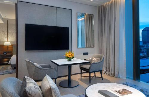 a hotel room with a table and chairs and a tv at Hyatt Regency Phnom Penh in Phnom Penh