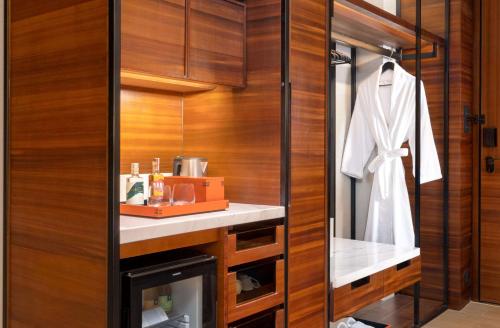 a dressing room with wood paneling and a white robe at Hyatt Regency Phnom Penh in Phnom Penh
