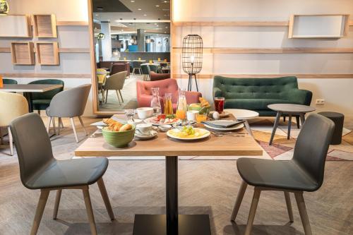 un comedor con una mesa con comida. en Holiday Inn - Mannheim City - Hauptbahnhof by IHG, en Mannheim