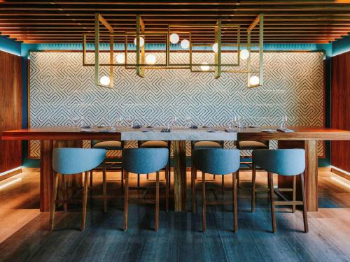 a dining room with a table and some blue chairs at Sofitel Mexico City Reforma in Mexico City