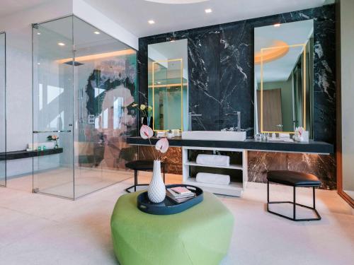 a bathroom with a green ottoman and a vase on a table at Sofitel Mexico City Reforma in Mexico City